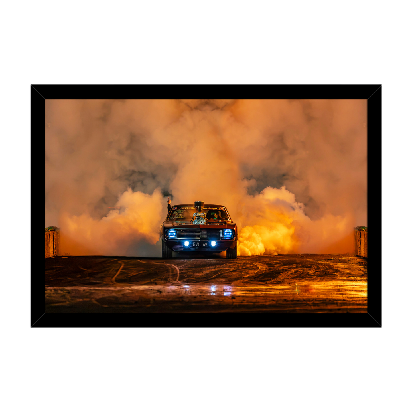 1969 Chevrolet Camaro performing a burnout surrounded by orange tyre smoke at night