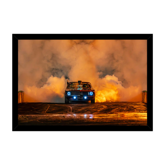 1969 Chevrolet Camaro performing a burnout surrounded by orange tyre smoke at night