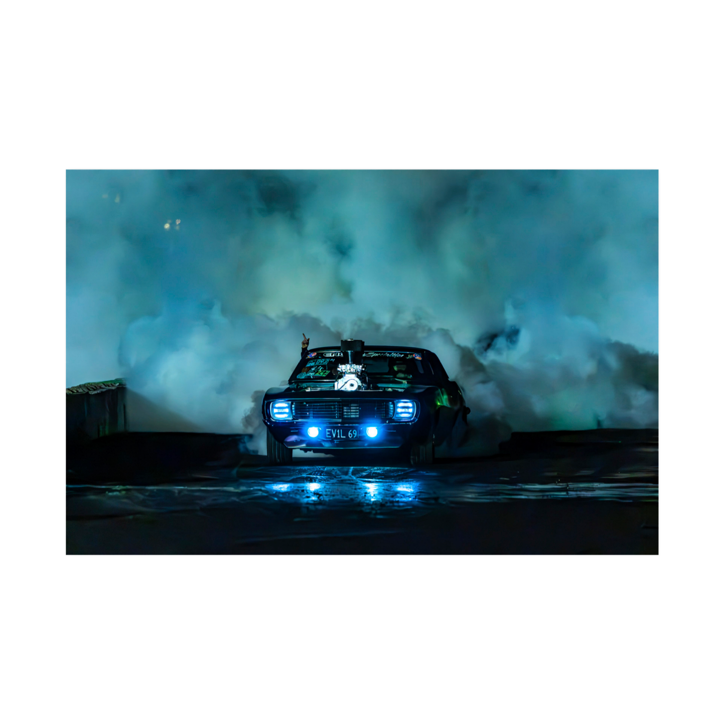 1969 Chevrolet Camaro performing a burnout with blue headlights and tyre smoke