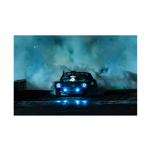 1969 Chevrolet Camaro performing a burnout with blue headlights and tyre smoke